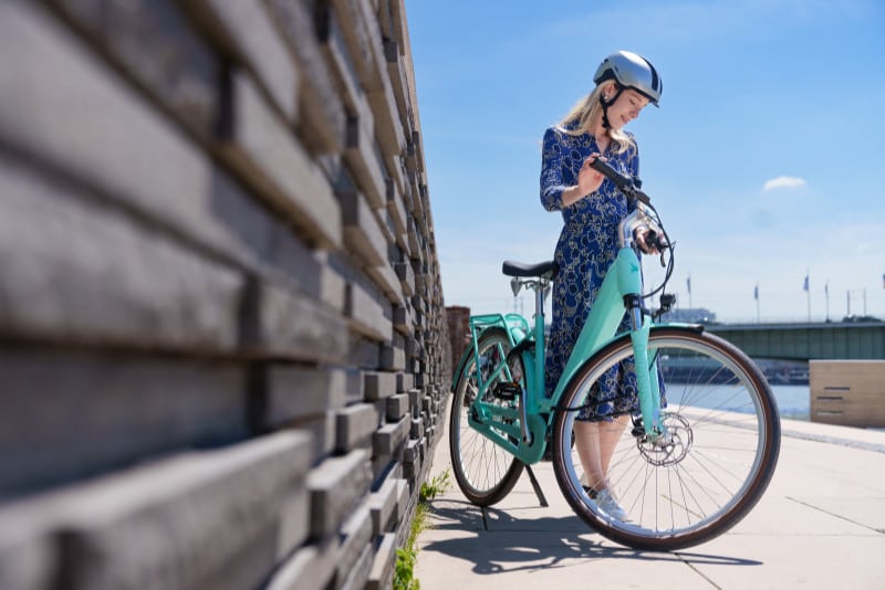 Frau sieht sich ihr E-Trekkingrad von Pegasus an